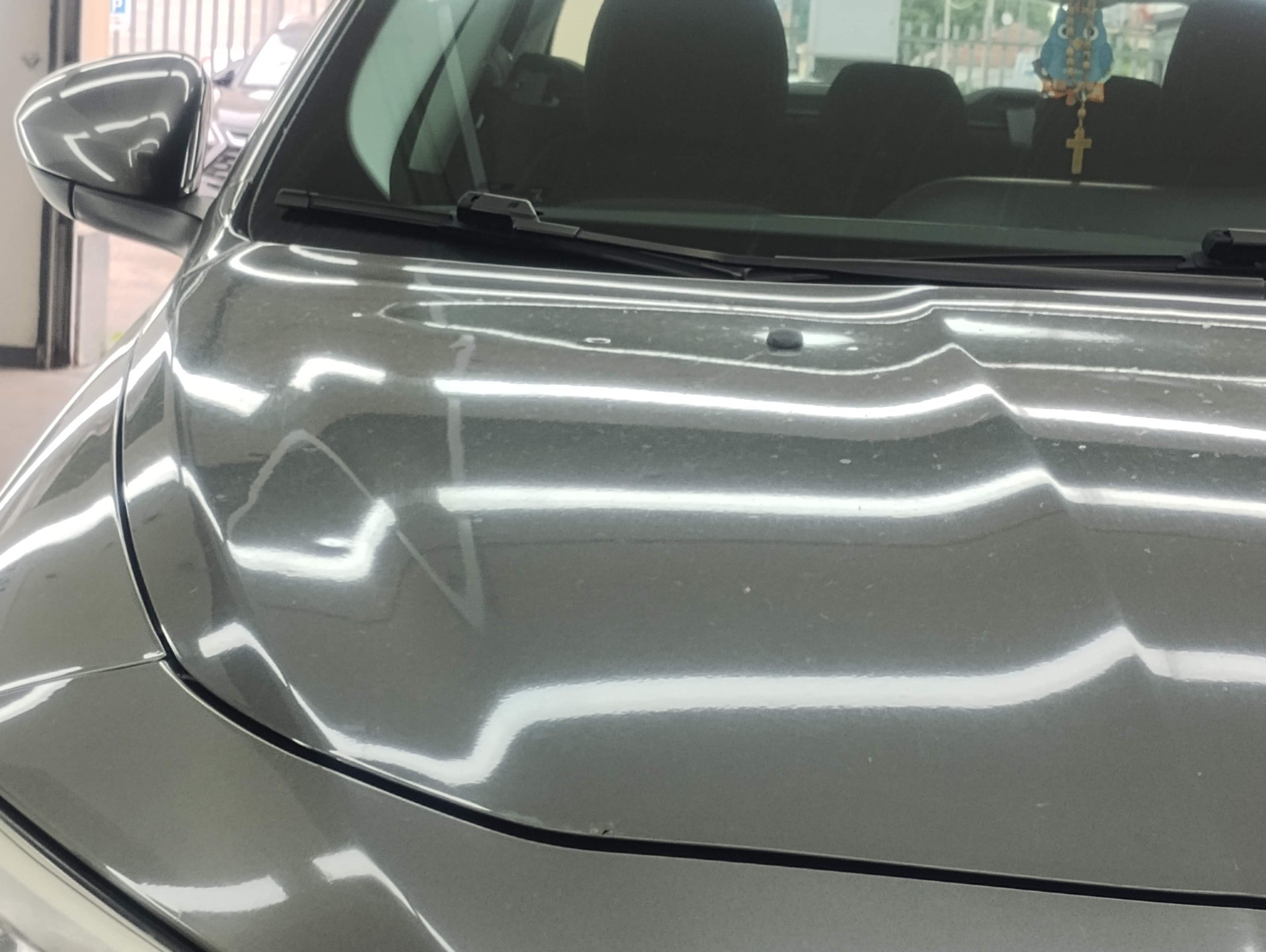 Perizia auto: cofano grigio con ammaccature